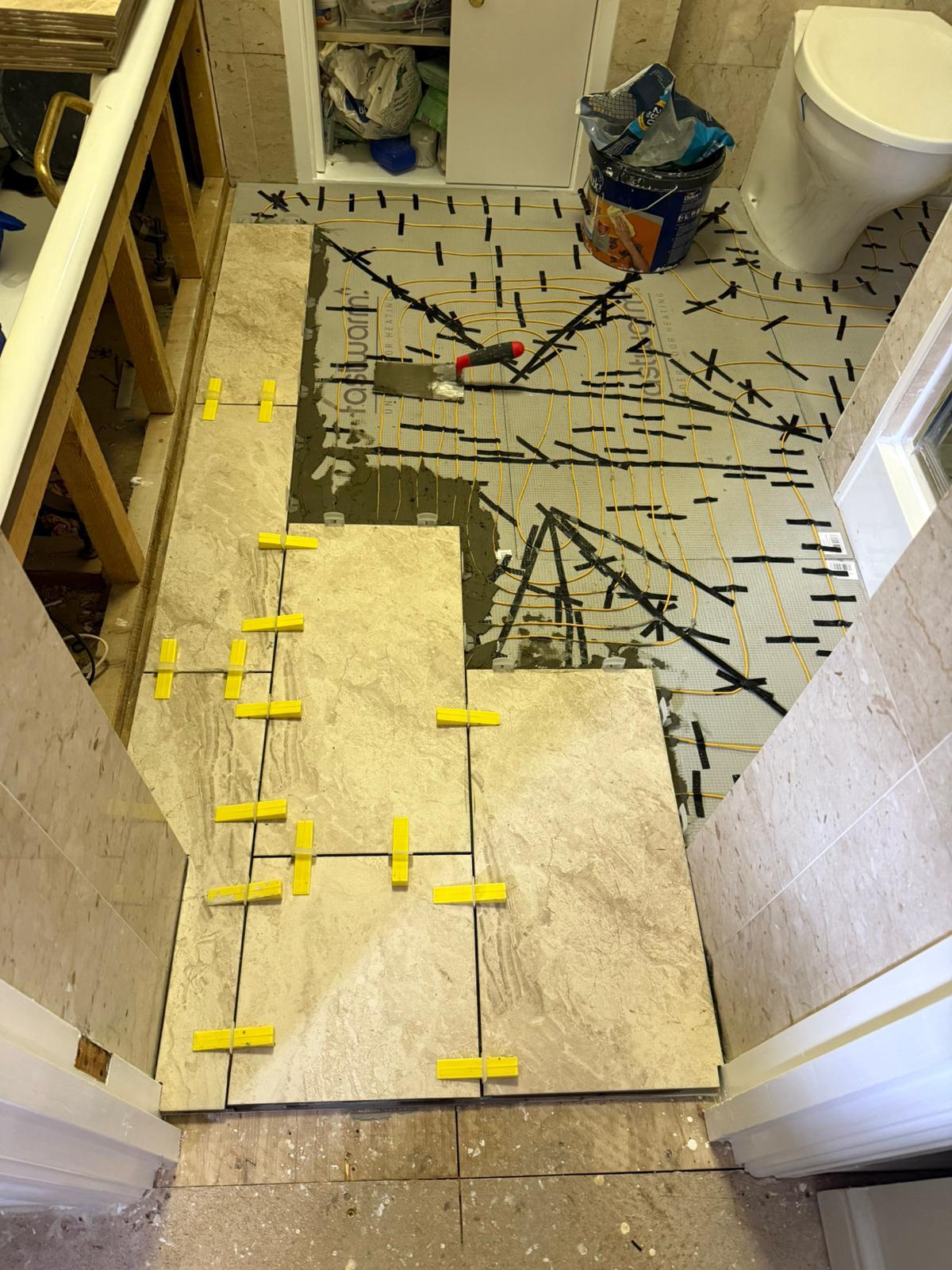 Bathroom floor tiles being fitted over electric underfloor heating