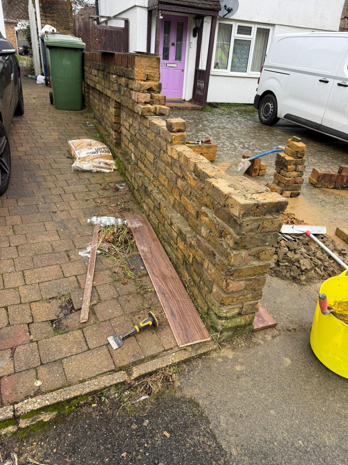 Front garden brick wall being rebuilt with matching bricks during repair