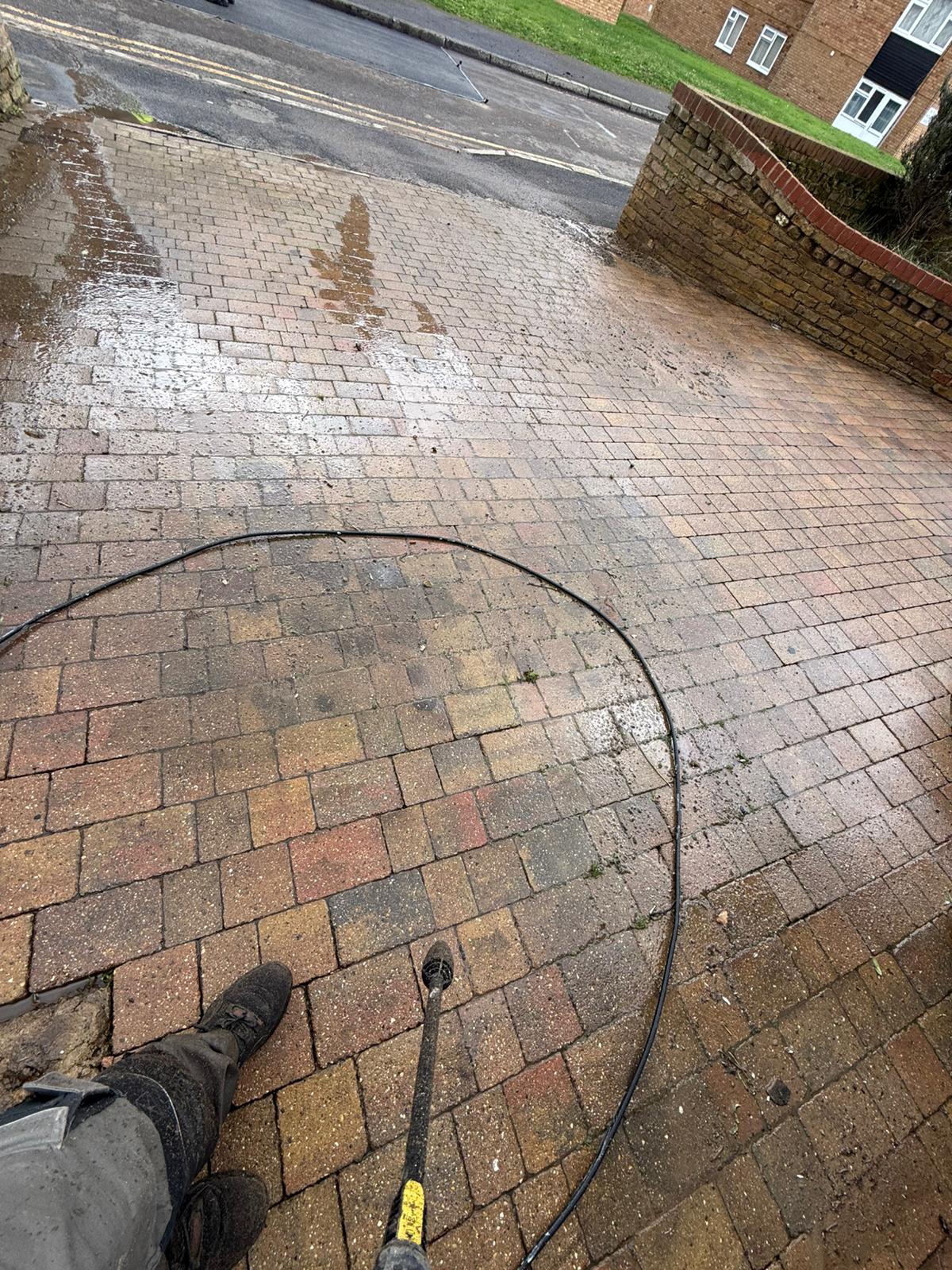 Block paving driveway being cleaned with a high-pressure jet washer