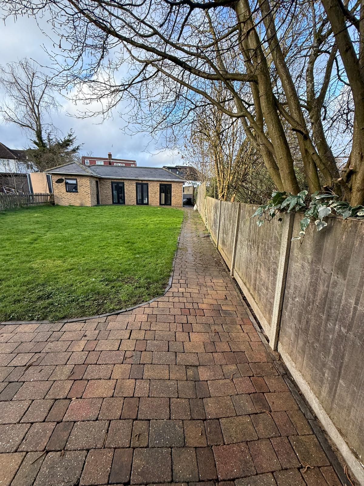 Garden block paving pathway cleaned alongside the lawn