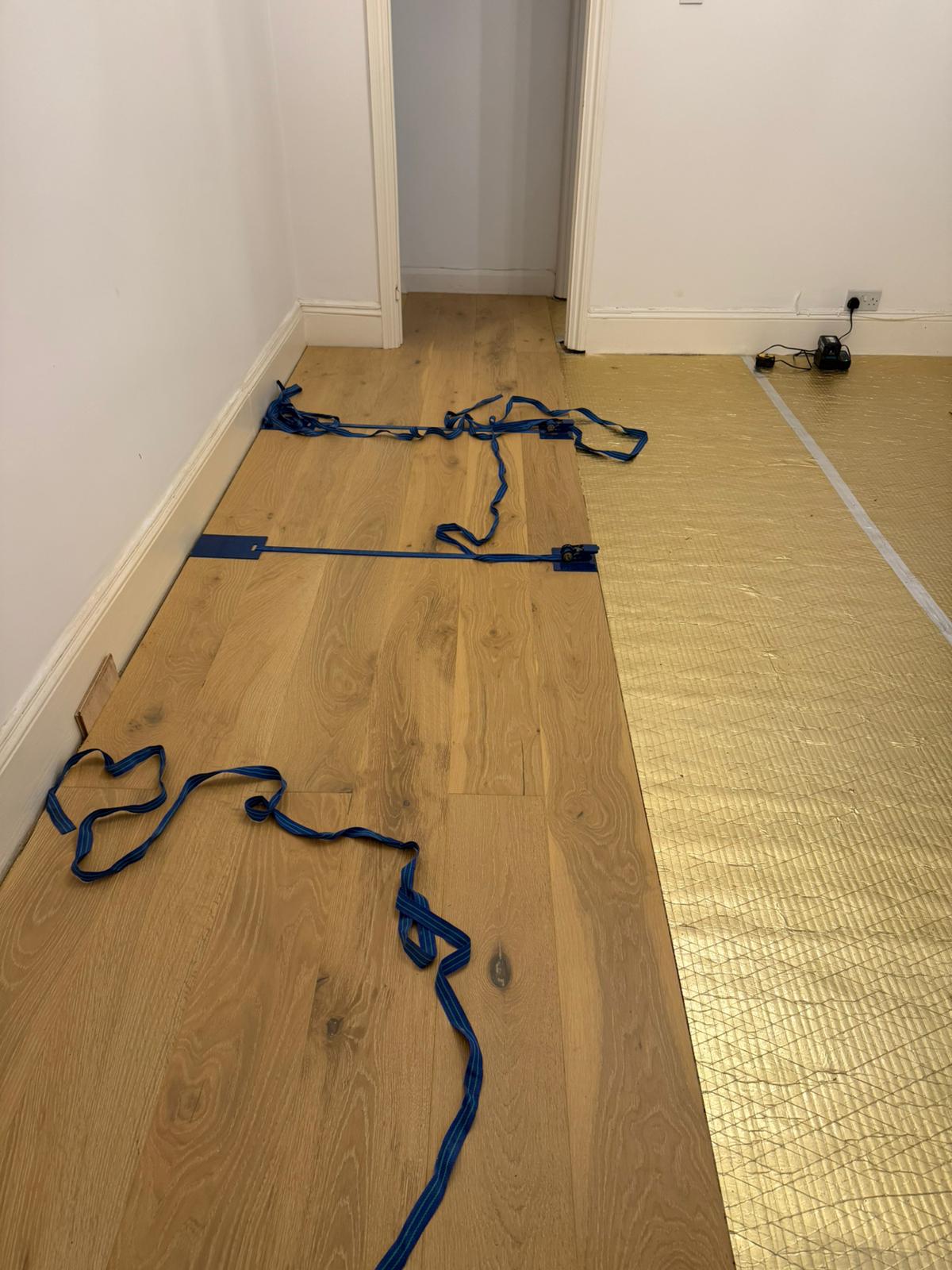 Engineered oak boards being laid and aligned during installation