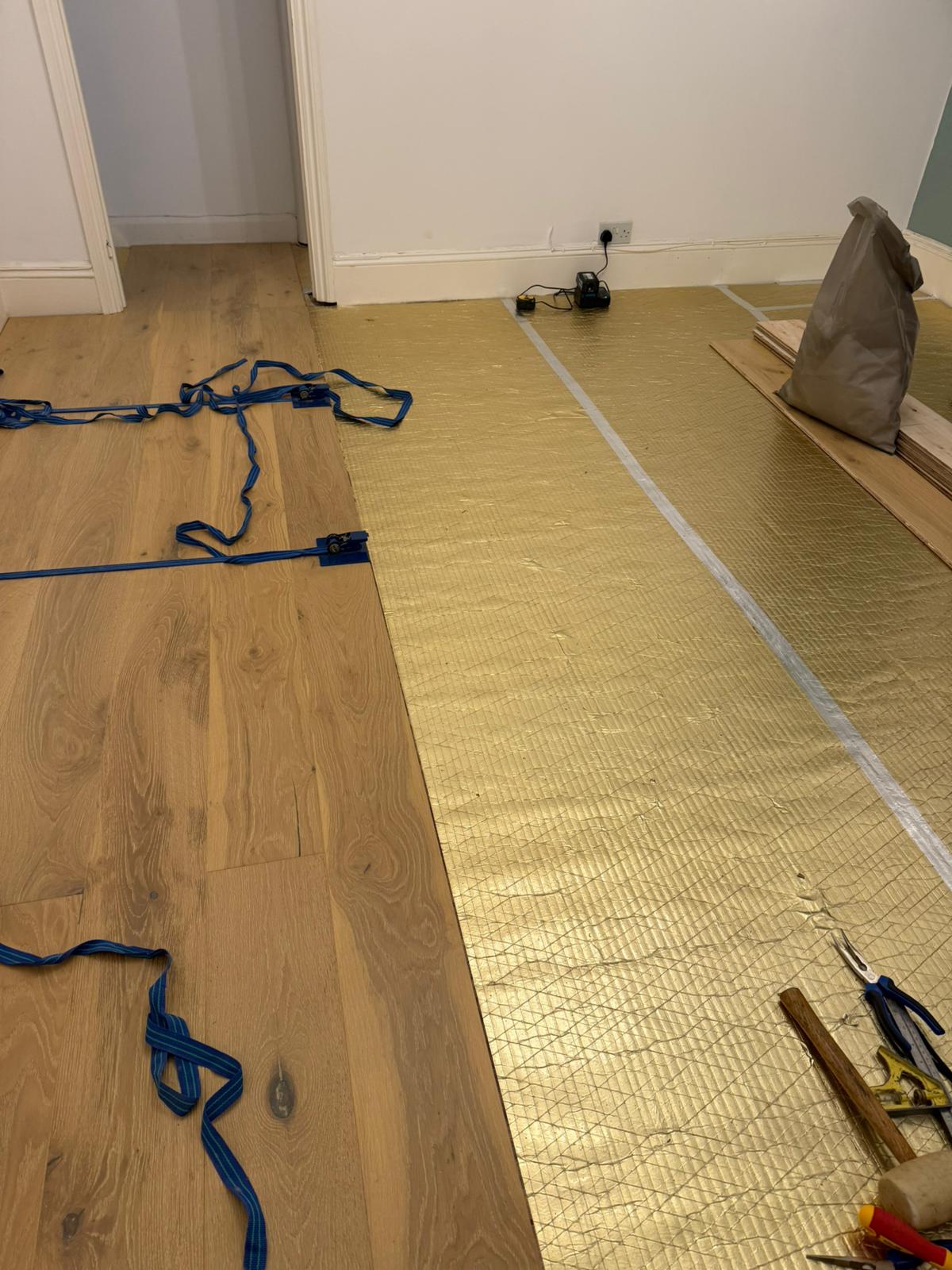 Engineered wood boards being installed over the new underlay