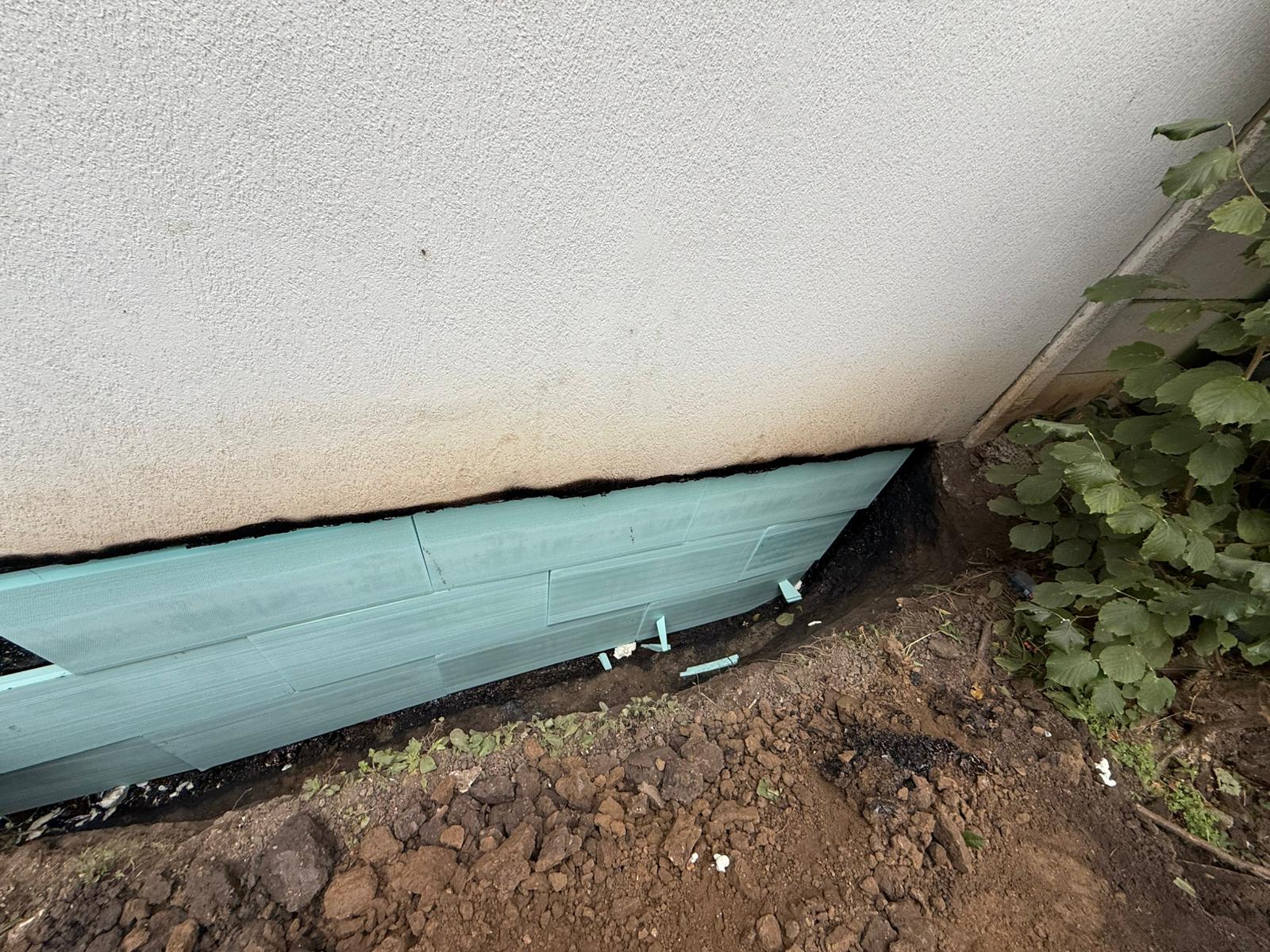 Dimpled drainage membrane fitted against the waterproofed foundation
