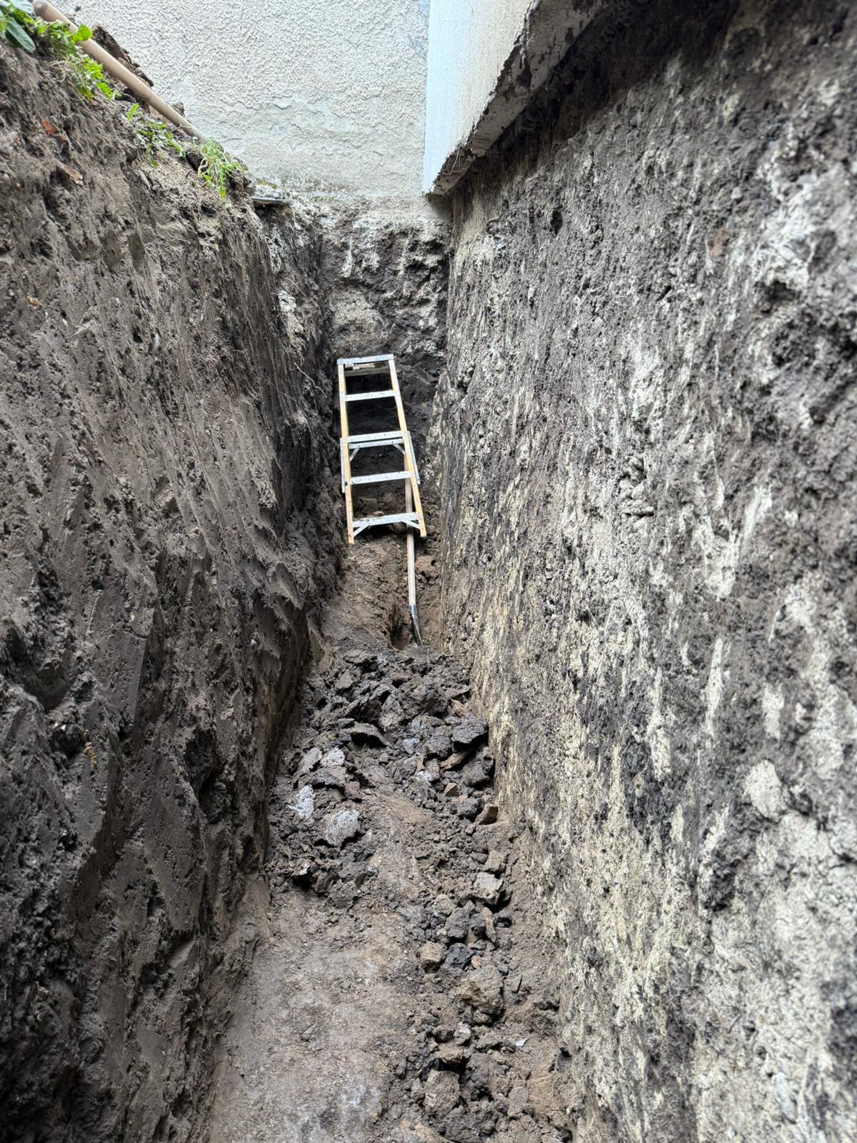 Deep trench excavated by hand alongside the foundation