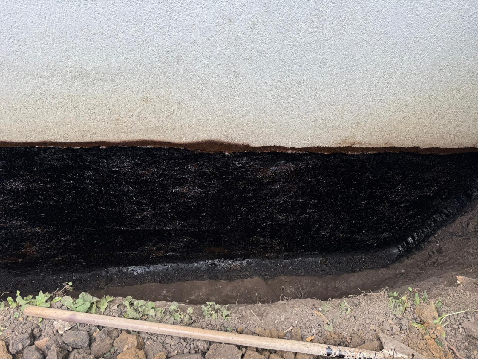 Bituminous waterproofing coating applied to the exposed wall base