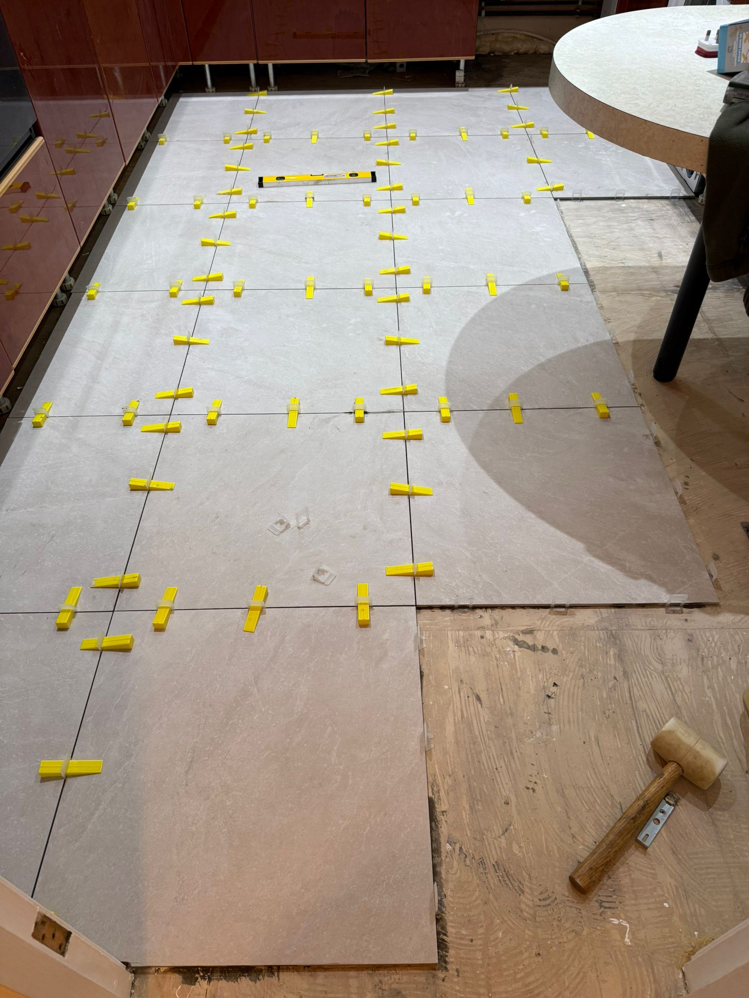 Kitchen floor renovation in progress with tile levelling clips